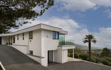 Corner of new home showing first floor balcony with frameless glass balustrade