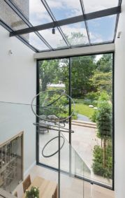 A glazed roof for extension , from which is suspended a sculptural light fitting, gives an atrium atmosphere to the interior